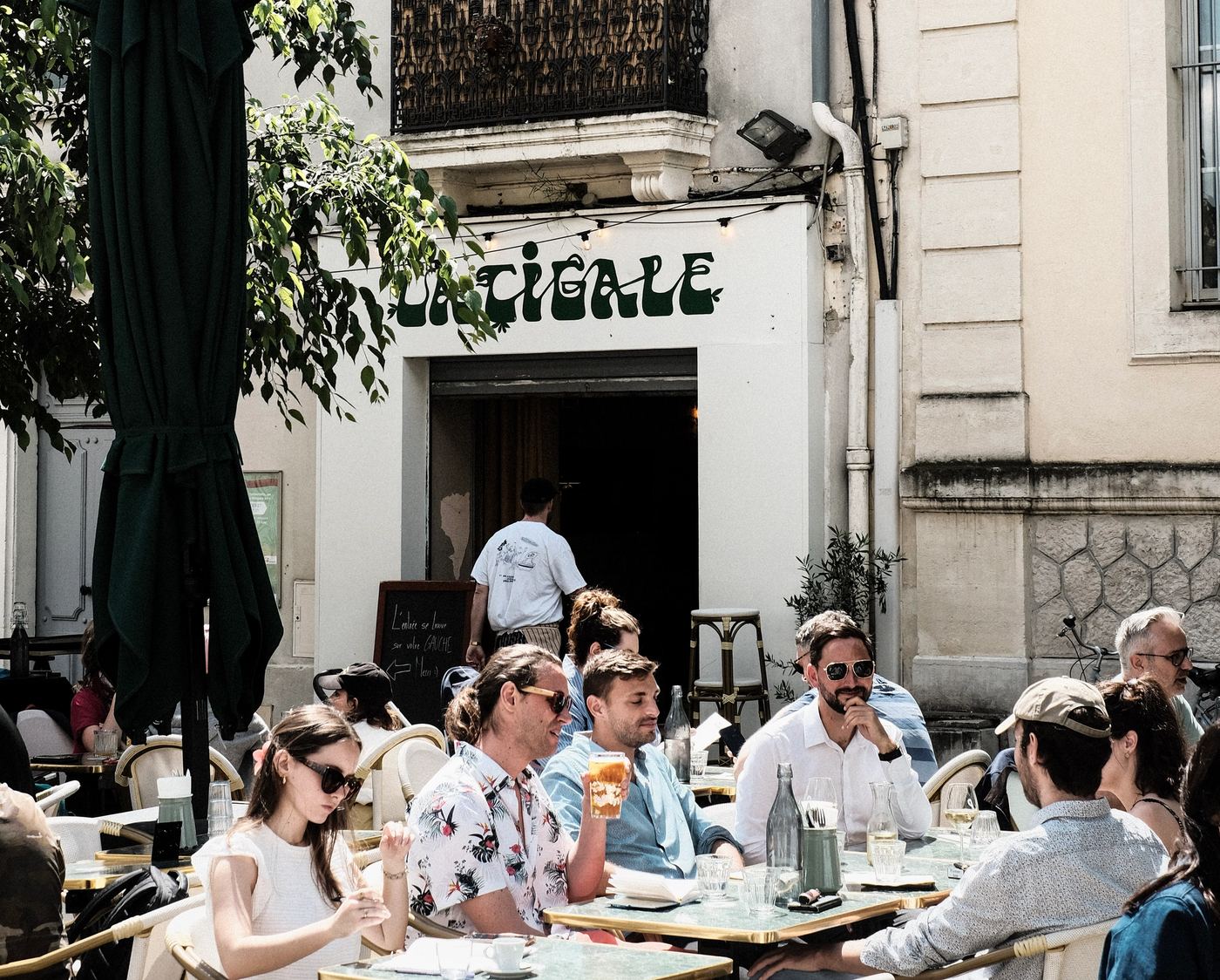 La terrasse de La Cigale, boulevard des Arceaux à Montpellier, tables occupées devant la façade du bar