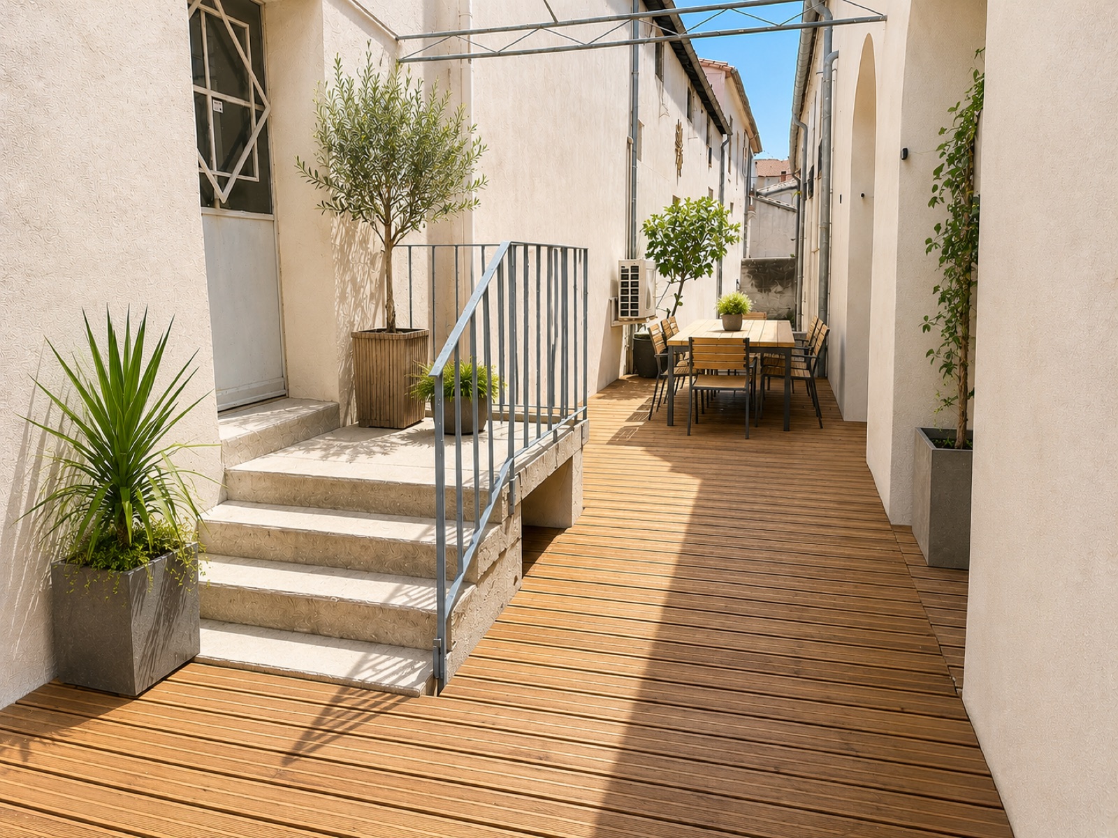 Vue générée par IA de la future terrasse en bois des bureaux Multani, oliviers en pot et table extérieure