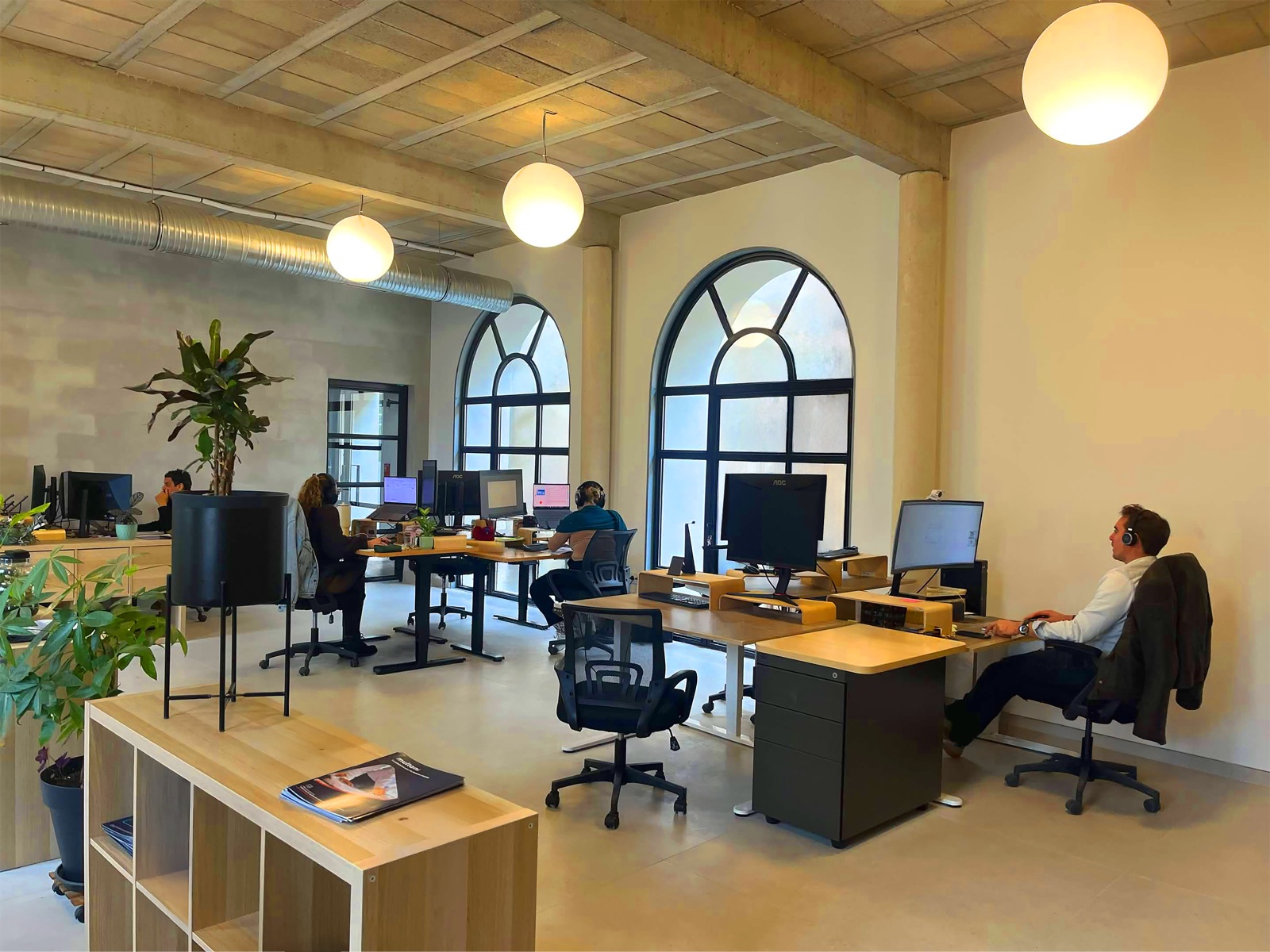 L’open space des bureaux Multani à Montpellier, grandes fenêtres en arc et postes de travail